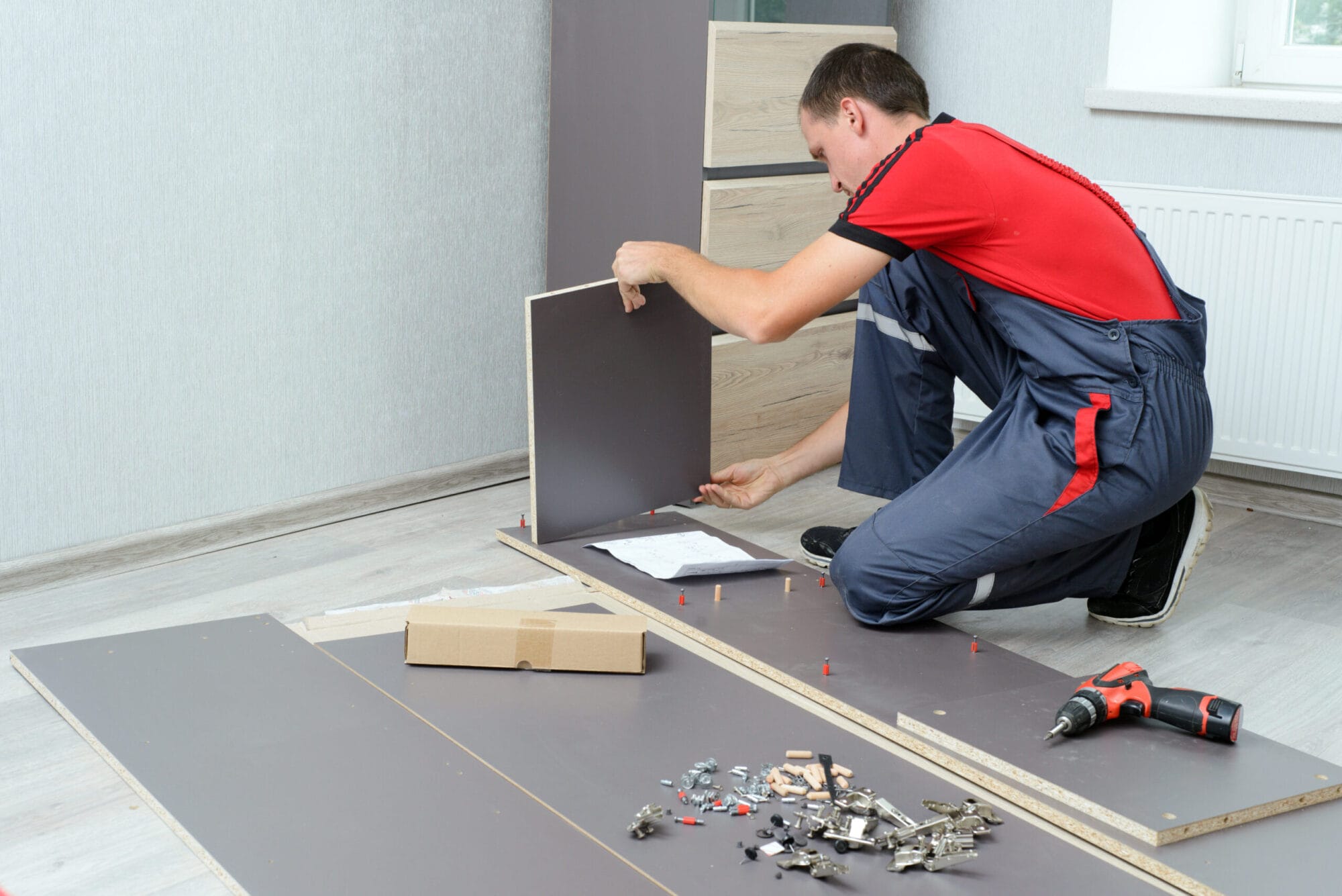 Man Putting Together Self Assembly Furniture In New Home