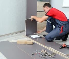 Man Putting Together Self Assembly Furniture In New Home